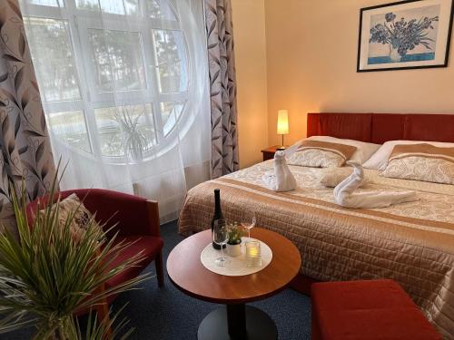 乌赫尔堡Wellness Hotel Staré Město的酒店客房配有一张床铺和一张桌子。