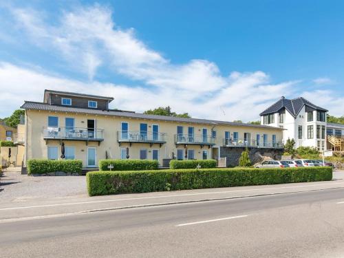 阿灵厄Apartment Henna - 50m from the sea in Bornholm by Interhome的白色的大建筑,设有蓝色的窗户和街道
