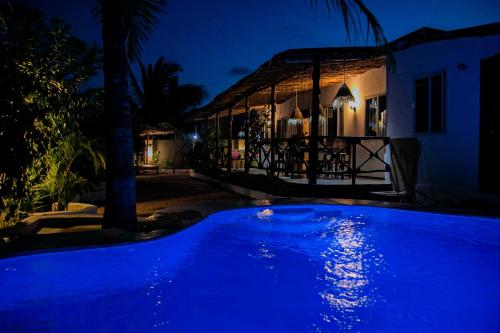 江比阿Villa Kikadini的夜晚在房子前面的一个蓝色泳池