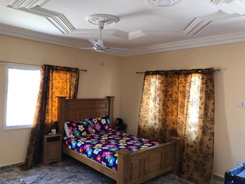 Sukuta3 bedrooms first story apartment的一间卧室配有床和两面窗帘