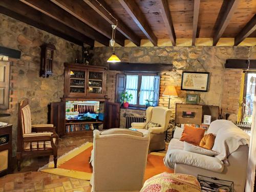 LlenínHeredad de la Cueste的客厅配有家具和石墙