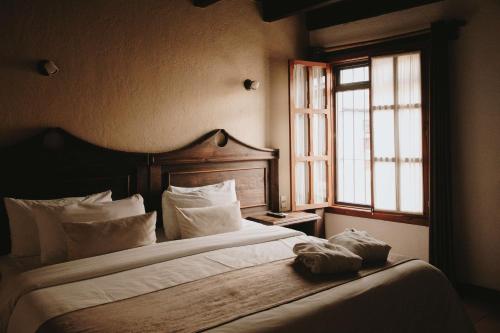 圣克里斯托瓦尔-德拉斯卡萨斯Docecuartos Hotel的卧室配有带白色枕头的床和窗户。