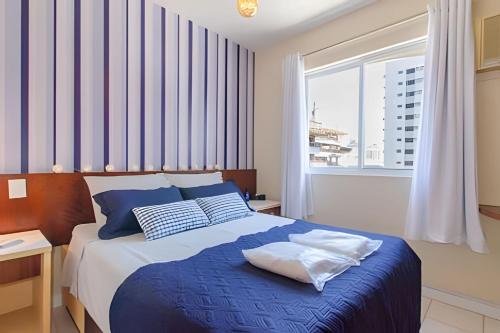 弗洛里亚诺波利斯Estúdio Próximo a Beira Mar的卧室配有蓝色和白色的床,设有窗户