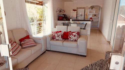 盖比姆Casa Ventos Guaibim的一间带2张白色沙发的客厅和一间厨房