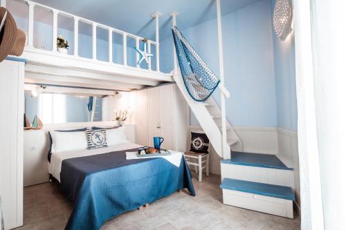 莫诺波利Chiasso S. Anna Relax Apartments near the sea的一间卧室设有双层床和楼梯。