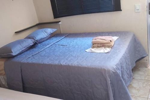 塞古罗港Mini Casa em Arraial d'Ajuda的一张带蓝色床单和枕头的床