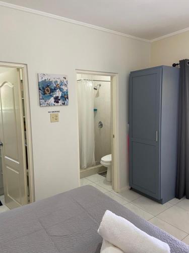 Banks1 Bed Cottage in Gated Community的一间带蓝色橱柜的卧室和一间浴室