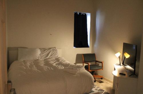 匹兹堡Private room in the heart of Oakland的卧室配有床、椅子和窗户。