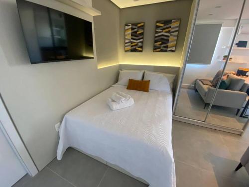 阿雷格里港Super compacto aconchegante.的卧室配有一张带镜子的白色床