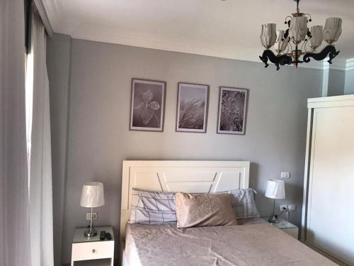 沙姆沙伊赫Serra Resort-Napa- Great Area的卧室配有一张床,墙上有三幅照片