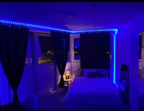 多特蒙德Dortmund City! Apartment DREAM的一间黑暗的房间,配有床和蓝色的灯光