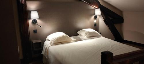 蒙特勒伊HÔTEL ROYAL MONTREUIL的卧室配有白色的床和2个枕头