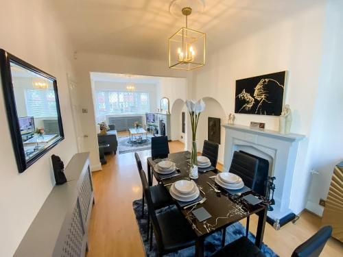 CatfordStunning Modern Cozy 5 star 3 bedroom house-Free Parking Greater London Metro Stations hosted by Tony的一间带桌子和壁炉的用餐室