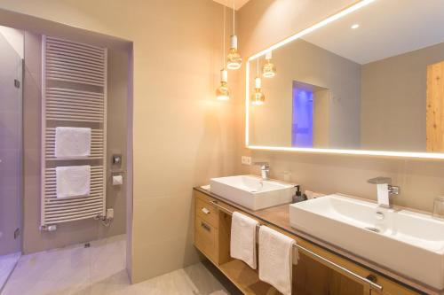 伊施格尔Alpenhotel Ischglerhof的浴室设有2个水槽和镜子