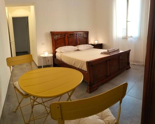 法诺Da Andrea的一间卧室配有一张床、一张黄色的桌子和椅子