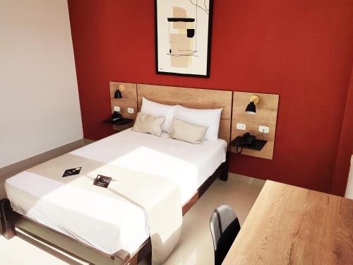 塔拉拉Rua Hoteles Talara的酒店客房设有两张床和一张桌子。