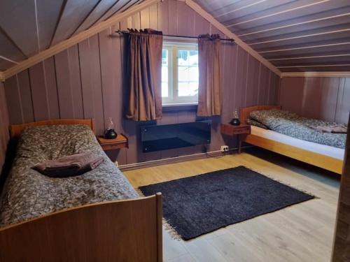 TorpoSolhaug的一间卧室设有两张床、一个窗户和一个地毯。