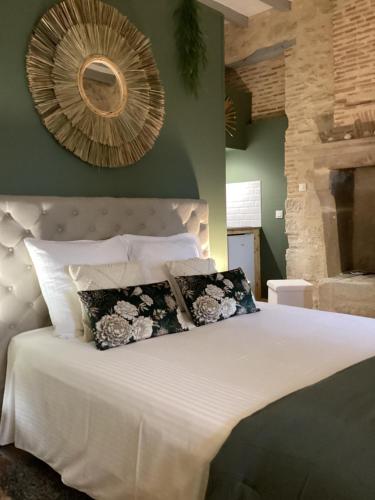 Saint-SèveLe Mas Réolais的卧室配有一张带两个枕头的大白色床