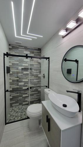 法哈多The Yellow Spot的一间带卫生间、水槽和镜子的浴室