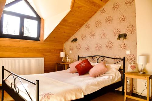 锡纳亚Cabana Stana Tarle的一间卧室配有带白色床单和红色枕头的床。