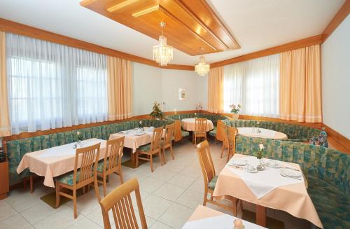 施韦夏特斯普林佐膳食公寓酒店的餐厅设有桌椅和窗户。