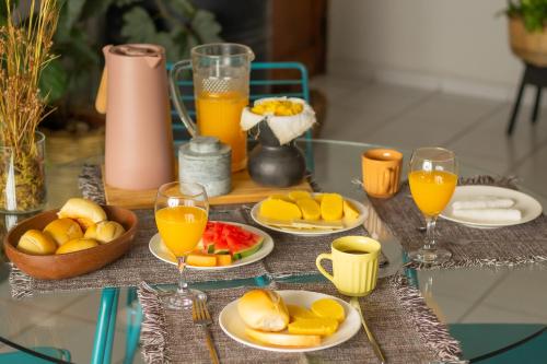 大坎皮纳Refúgio Urbano的一张桌子,上面放有水果盘和橙汁杯