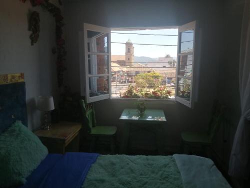 锡帕基拉MACONDO apartamento turistico tematico的一间卧室配有一张床,窗户配有钟楼