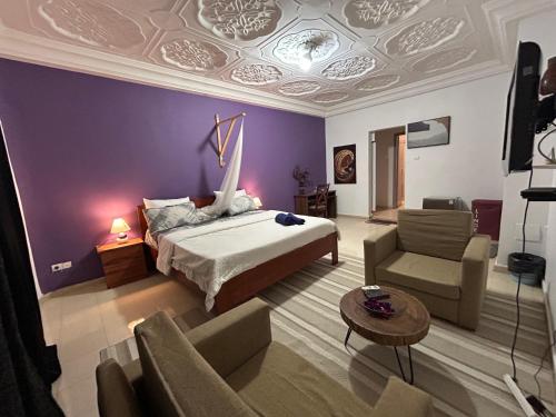 达喀尔Villa Jade的一间卧室配有一张床、一张沙发和一张桌子