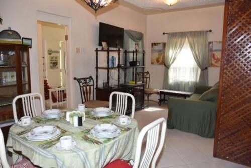 欧丘里欧Aileen Palm Cove Ja的客厅配有桌椅和沙发