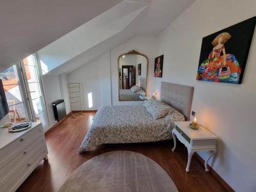VillabáñezRomántico apartamento con terraza y piscina的卧室配有一张床,墙上设有镜子