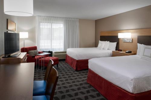 里士满TownePlace Suites by Marriott Richmond的酒店客房设有两张床和电视。