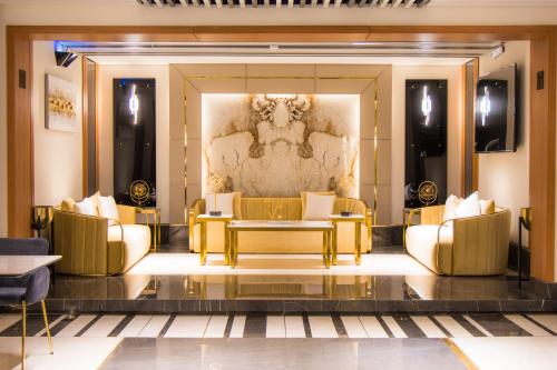 麦地那فندق كلاودز Clouds Hotel的大堂配有金色家具和墙上的绘画