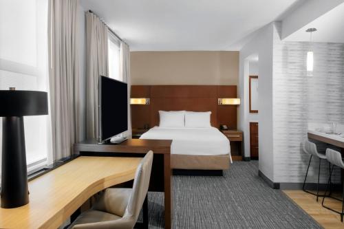 诺沃克Residence Inn by Marriott Norwalk的配有一张床和一张书桌的酒店客房