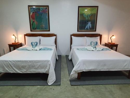 波尔多·格尼拉AV Suites的配有两张床铺的房间,桌子上放着两盏灯