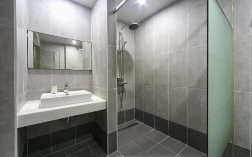 釜山Yeonsan Oops Hotel的一间带水槽和淋浴的浴室