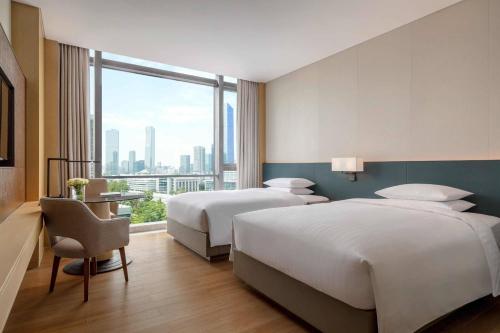 深圳深圳湾万怡酒店的酒店客房设有两张床和大窗户。