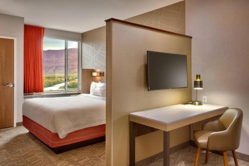 摩押摩押春季山丘套房万豪酒店的配有一张床、一张书桌和一扇窗户的酒店客房