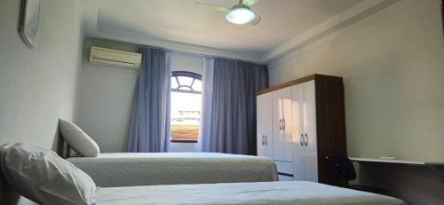 伊塔佩米林河畔卡舒埃鲁CAXU HOSTEL的一间卧室设有两张床和窗户。