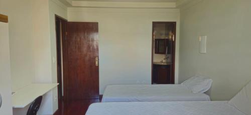 伊塔佩米林河畔卡舒埃鲁CAXU HOSTEL的小房间设有两张床和一扇门