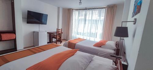 新洛哈Hotel Israel - Lago Agrio的酒店客房设有两张床和一台平面电视。