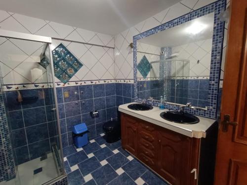 苏克雷Para familias con niños的浴室设有2个盥洗盆、淋浴和镜子。