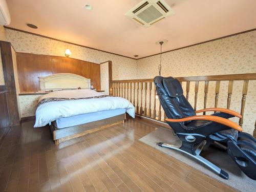 大村市SKY Ocean-terace Omura的一间卧室配有一张床、一张桌子和一把椅子