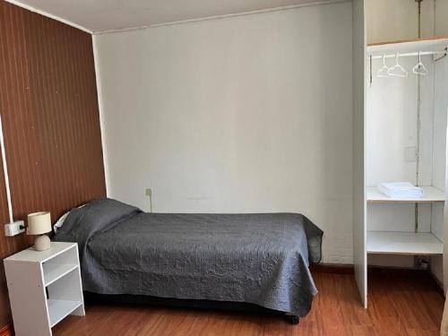 奇廉Departamentos Arrayán的卧室配有床和白色架子