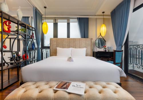 河内Golden Legend Boutique Hotel的一间卧室配有一张白色大床,上面有书
