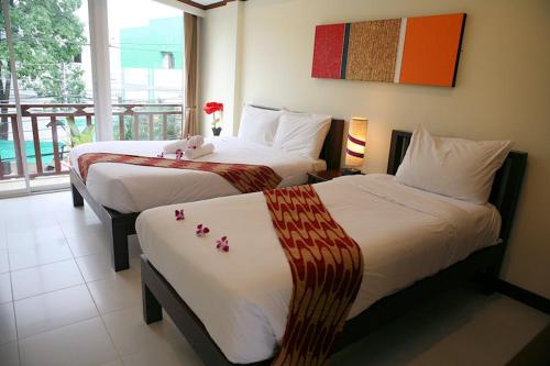 坤敬孔敬兰花酒店的酒店客房,配有两张带鲜花的床