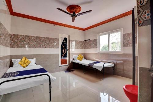 OngoleSPOT ON Hotel Maha Lakshmi的一间卧室设有两张床和窗户。