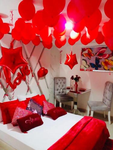 巴兰基亚Hotel Platinum Luxury的卧室配有悬挂在床上的红色气球