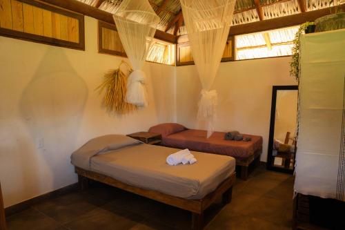 特隆戈内斯Surf Lodge at Casa Mexibali, Troncones的带两张床和镜子的客房