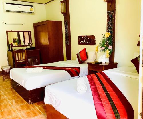 Ban Khun Yuam米特胡恩佑姆酒店的一间酒店客房,房间内设有三张床