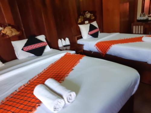 Ban Khun Yuam米特胡恩佑姆酒店的客房配有两张带橙色和黑色枕头的床。